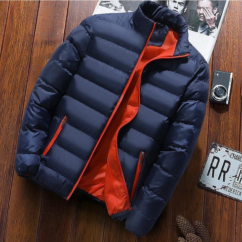 Dark blue puffer jacket with orange lining displayed on a wooden background