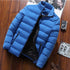 Sky blue puffer jacket with black lining displayed on a wooden background