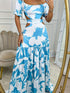 a lady wearing sky blue solid botanical printed long dress with drop shoulders and cut out waist design