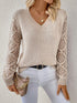 Woman wearing a beige V-neck pullover sweaters with hollow long sleeves