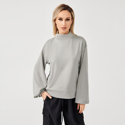 A lady wearing grey high neck sweatshirt