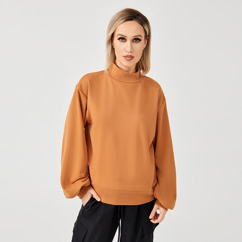 A lady wearing orange high neck sweatshirt
