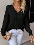 Woman wearing a black V-neck pullover sweaters with hollow long sleeves