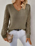 Woman wearing an army green V-neck pullover sweaters with hollow long sleeves